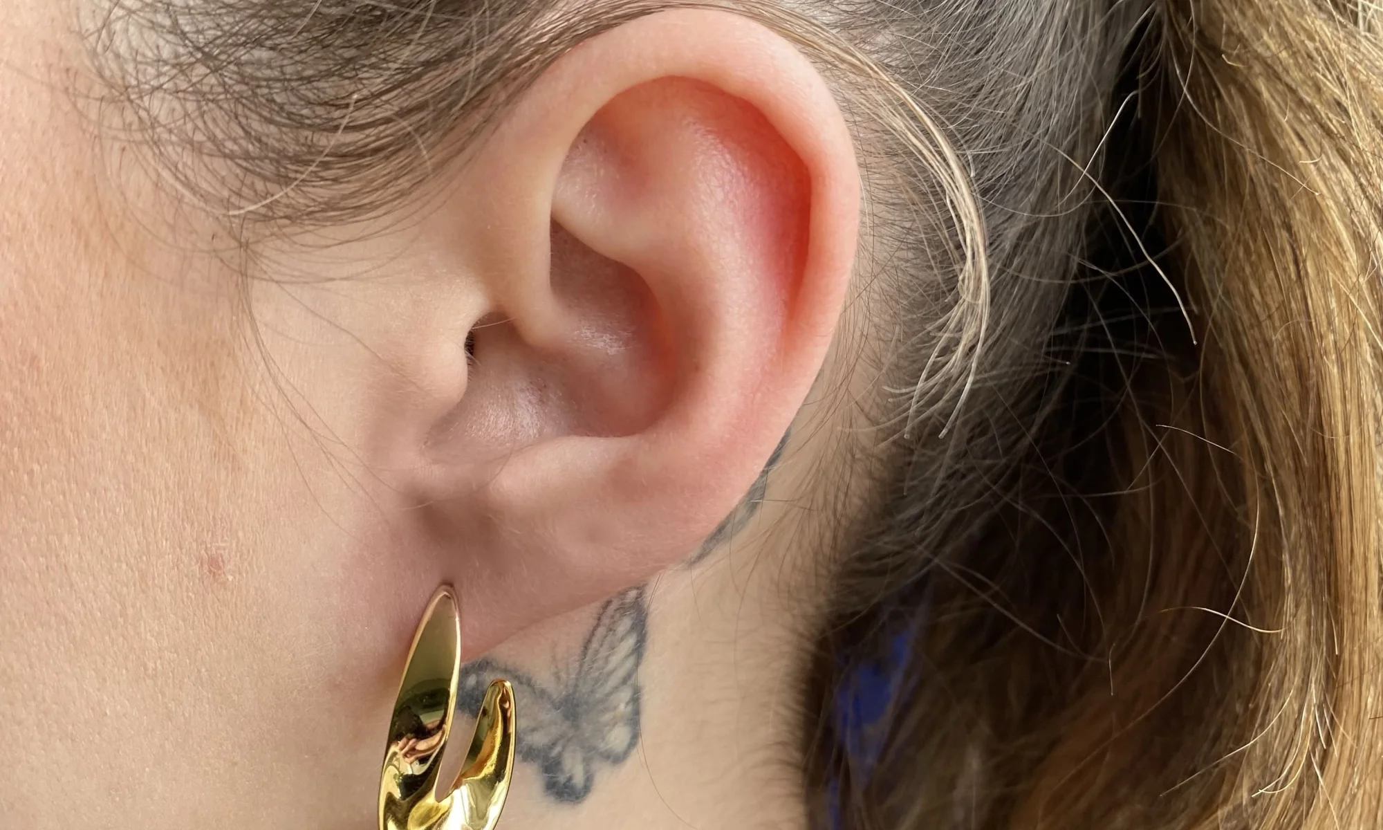 Gouden swirl oorsteker van opzij