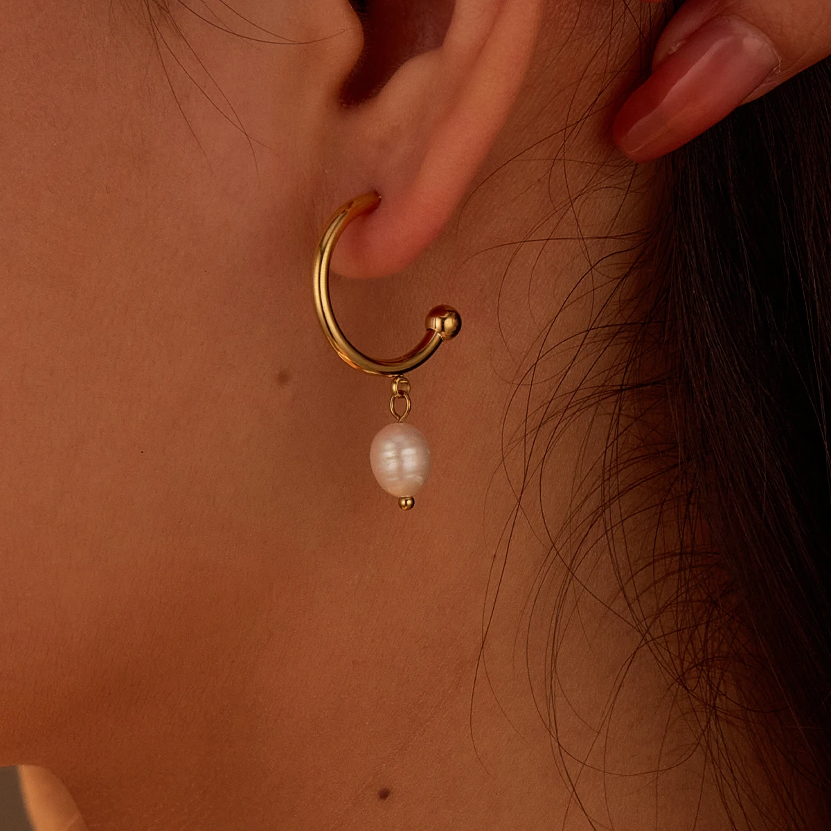 Goudkleurige rondo pearl oorstekers met pareldetail - zijkant